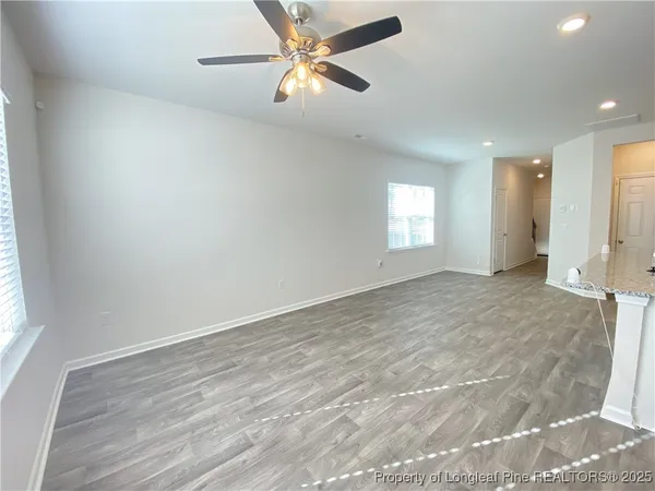 an empty room with fan and windows