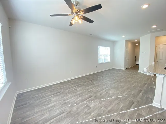 an empty room with fan and windows