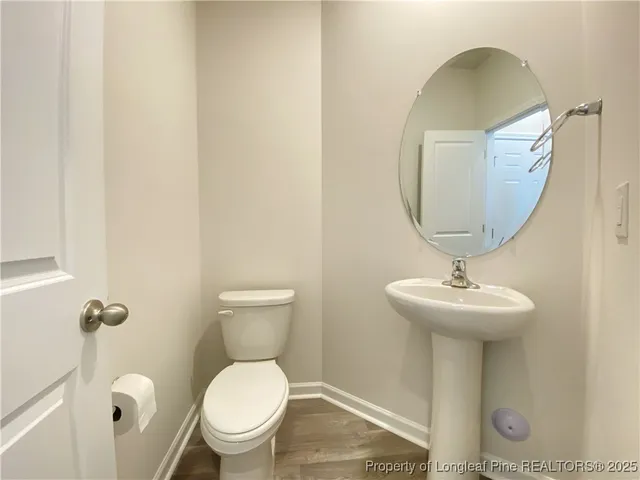 a bathroom with a toilet a sink and mirror
