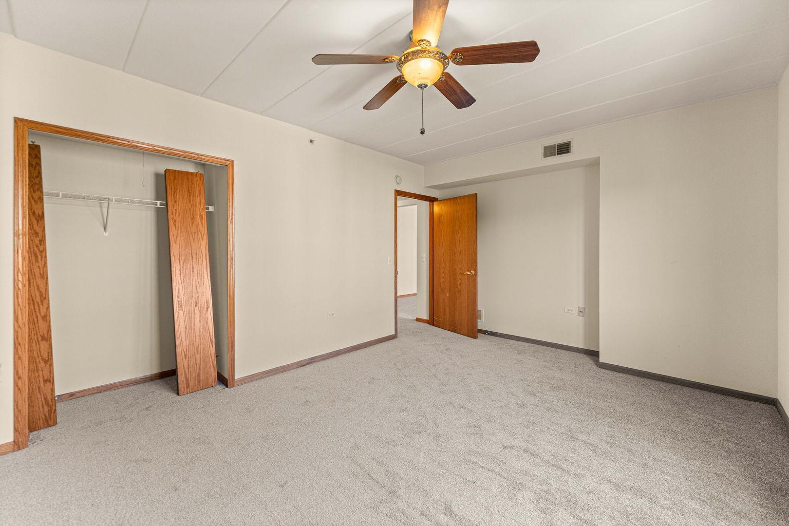 11901 Windemere Court, Unit 301 Orland Park, IL 60467 - Photo 7 of 27 an empty room with a chandelier fan and windows