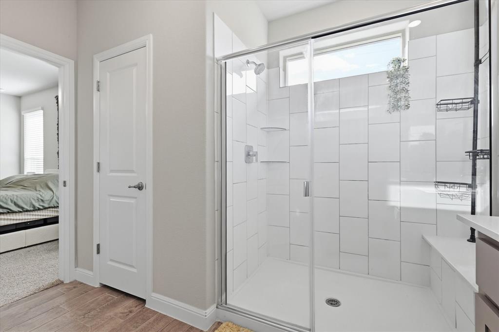 141 Medina Lane Rhome, TX 76078 - Photo 22 of 36 Walk-in shower with clear glass enclosure, white subway tile surround, integrated shower bench, and a transom window