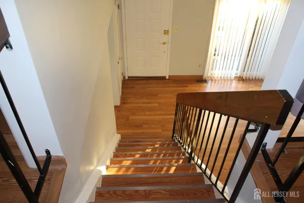 a view of a hallway with wooden floor and staircase