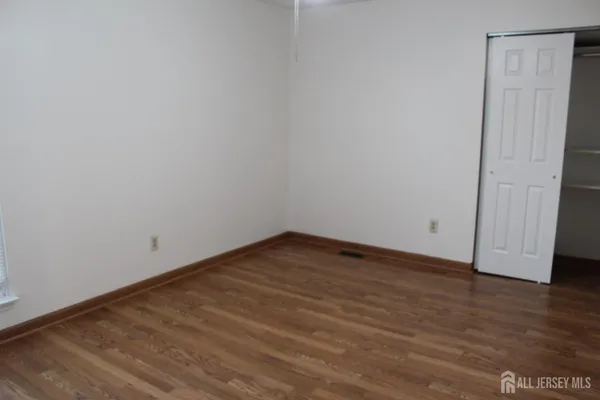 a view of a hallway with wooden floor and fence