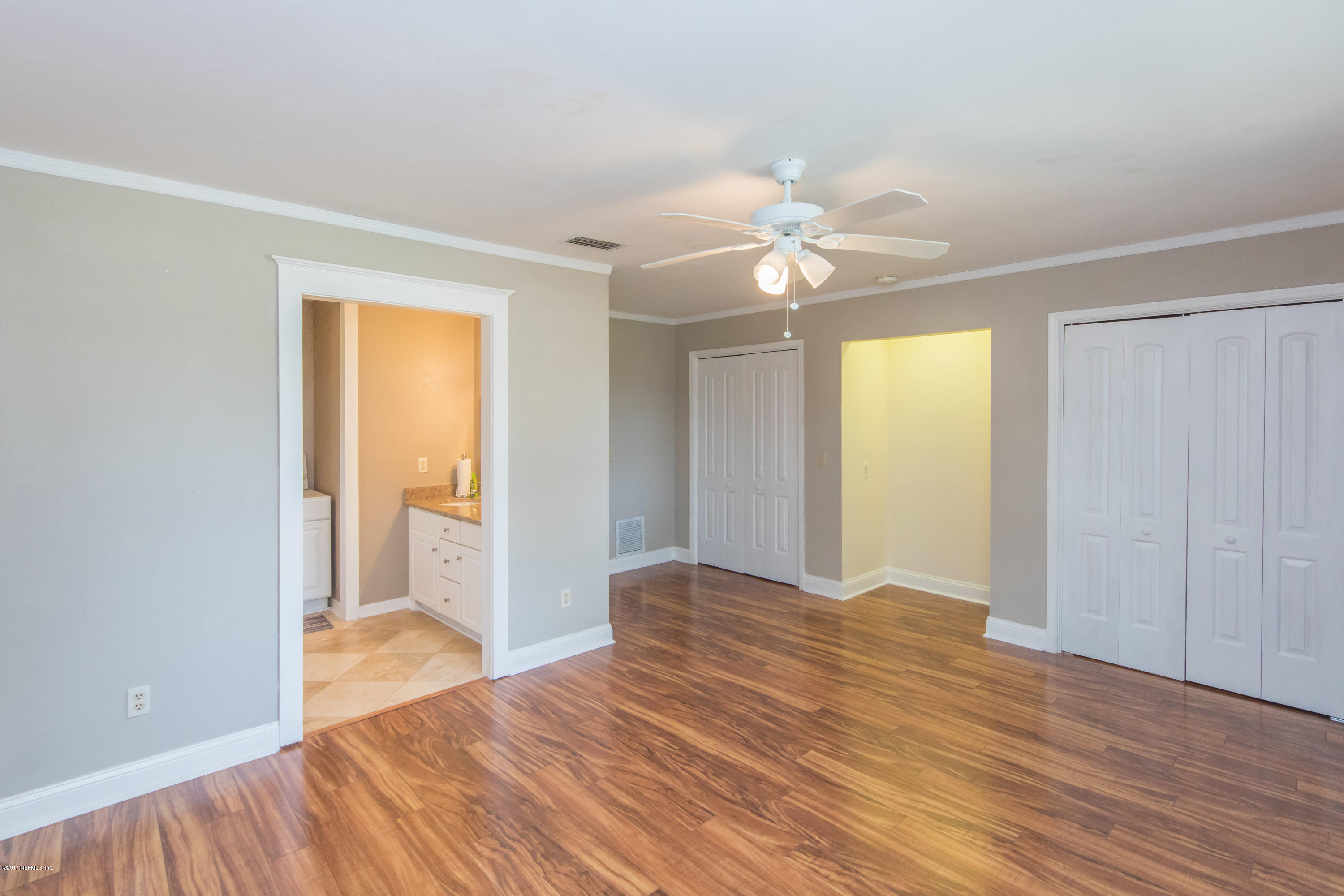 6255 Little Lake Geneva Road Keystone Heights, FL 32656 - Photo 26 of 59 a view of a bedroom with wooden floor and a ceiling fan