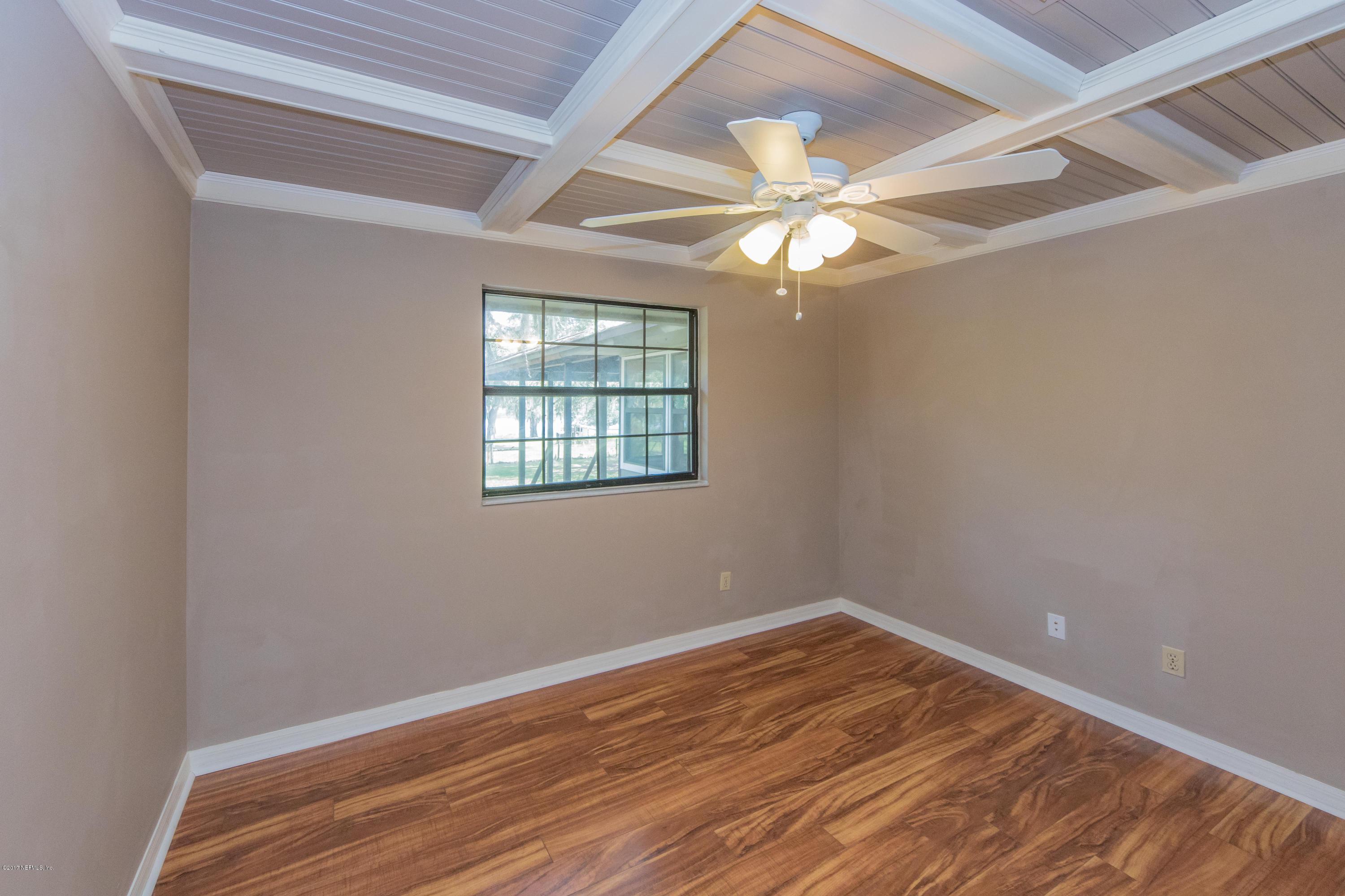 6255 Little Lake Geneva Road Keystone Heights, FL 32656 - Photo 31 of 59 an empty room with wooden floor fan and windows