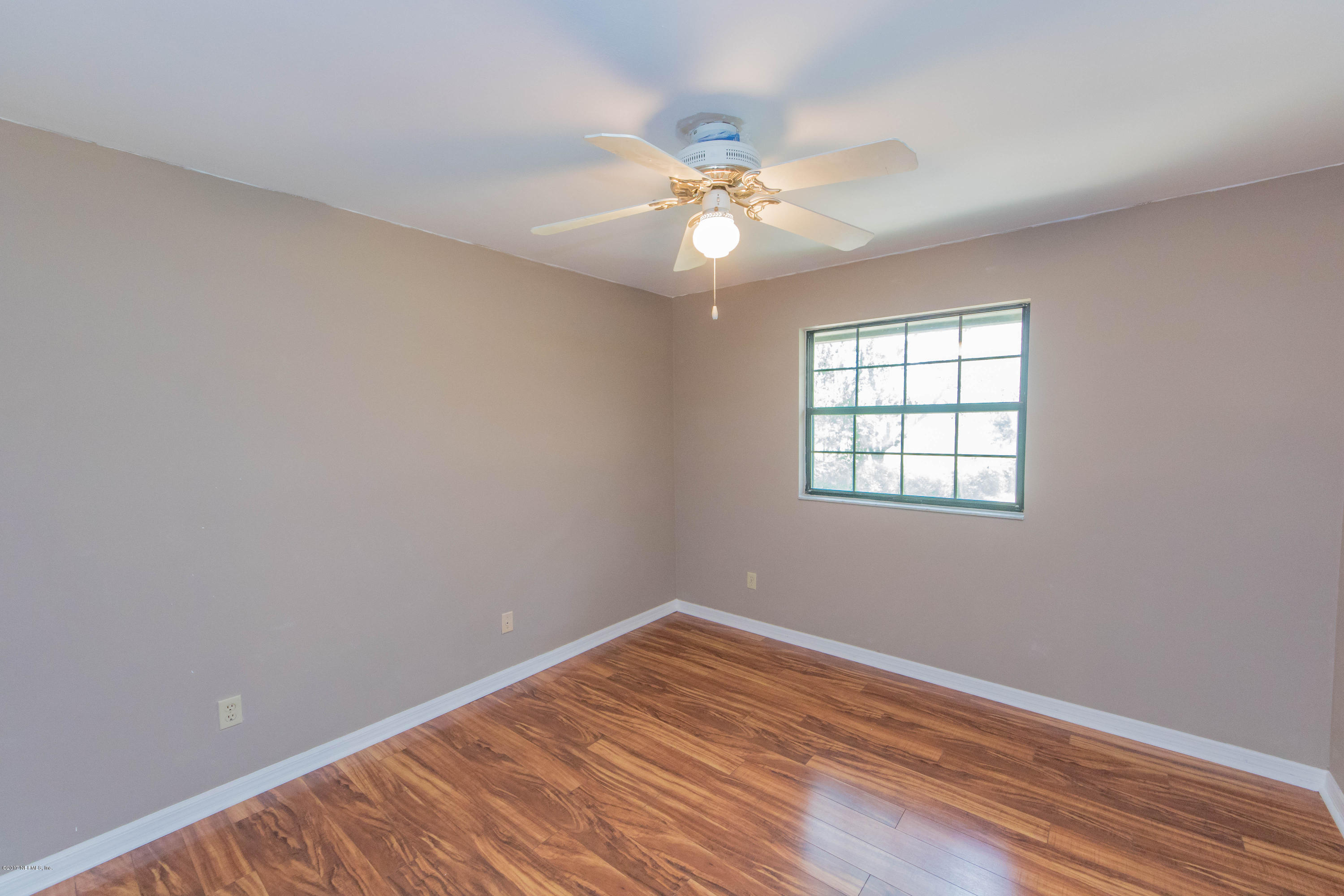 6255 Little Lake Geneva Road Keystone Heights, FL 32656 - Photo 32 of 59 an empty room with wooden floor fan and windows