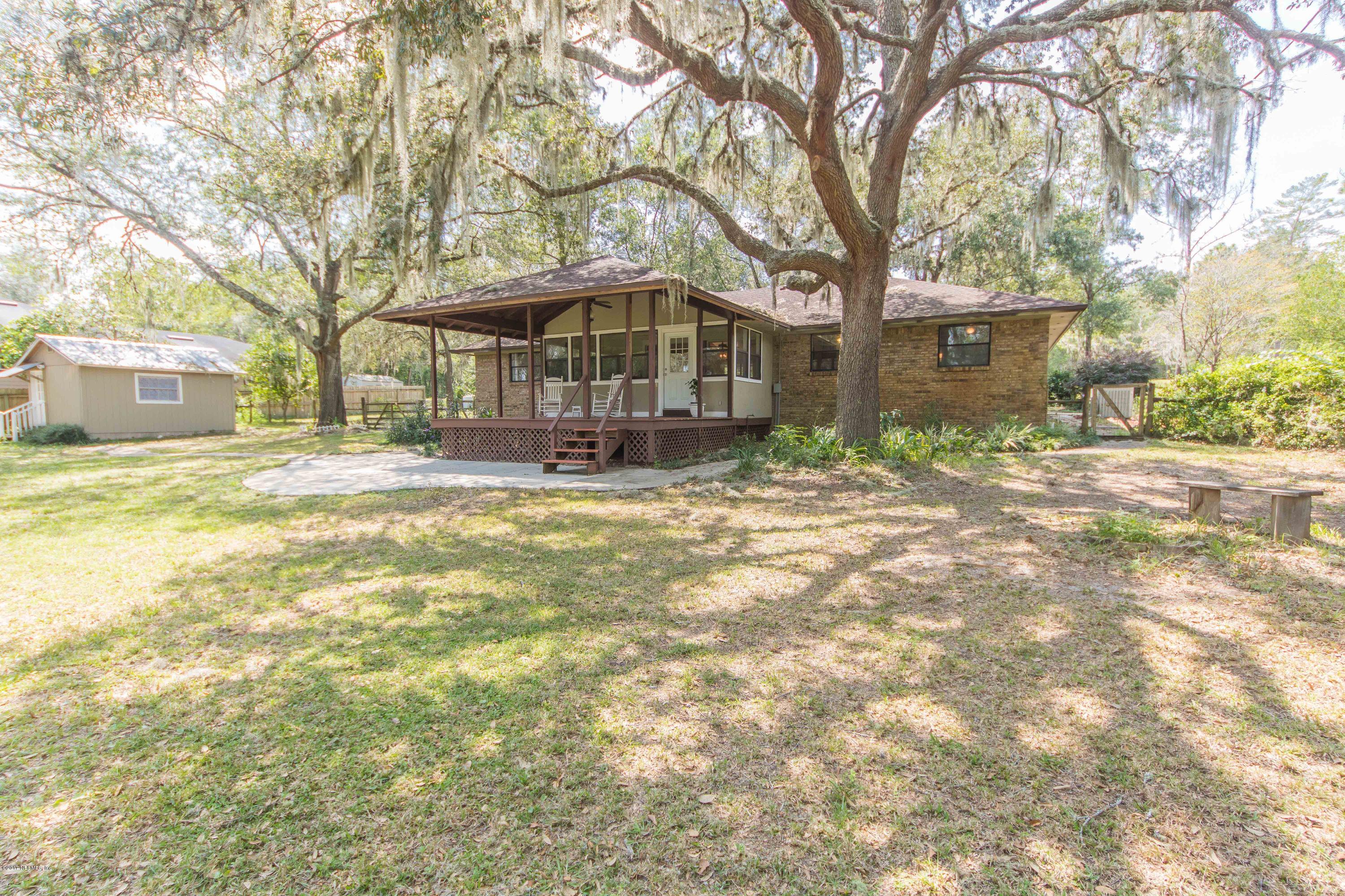 6255 Little Lake Geneva Road Keystone Heights, FL 32656 - Photo 39 of 59 a view of a yard in front of a brick house with large tree