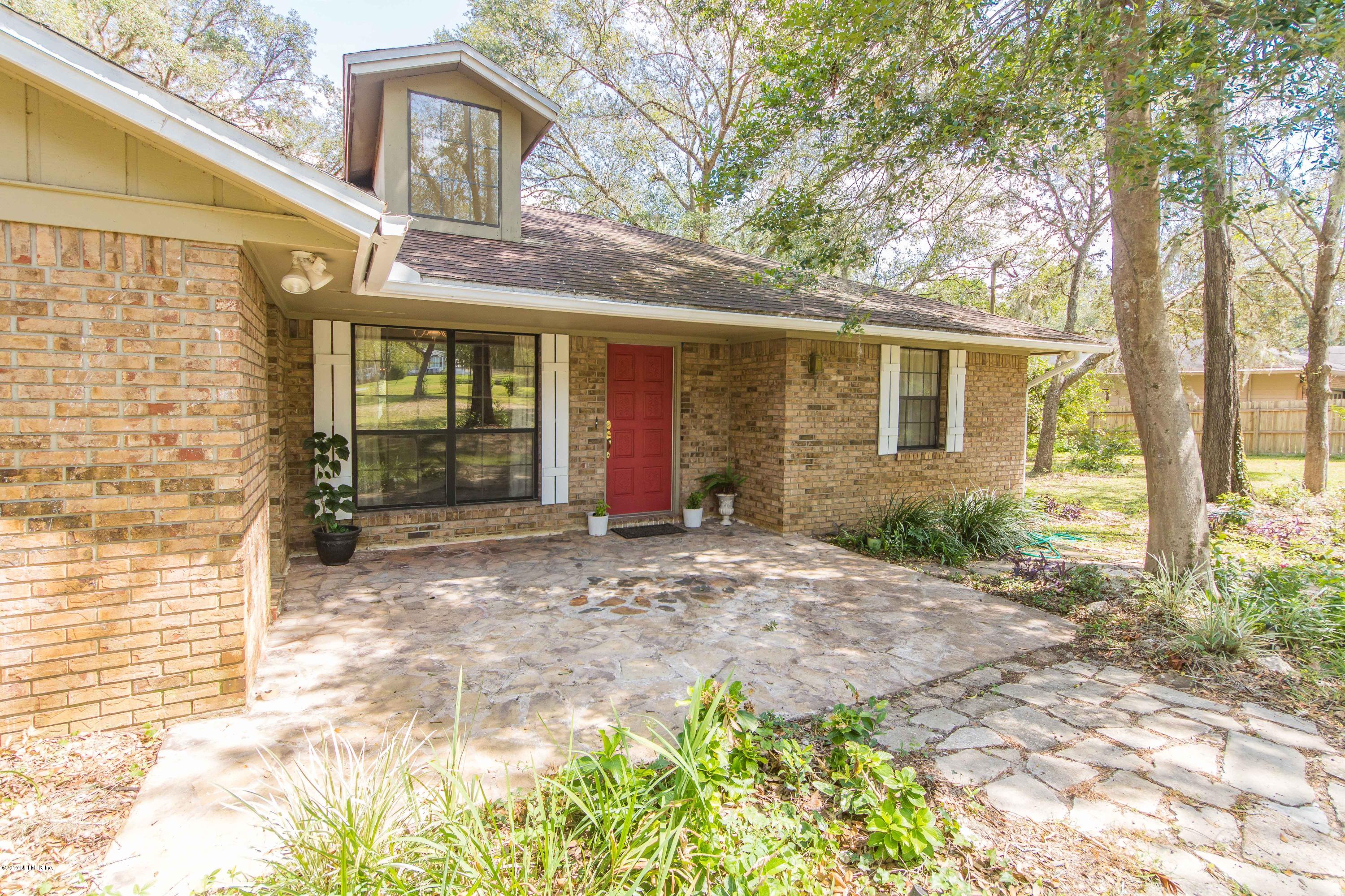 6255 Little Lake Geneva Road Keystone Heights, FL 32656 - Photo 5 of 59 a view of a brick house with many windows and plants