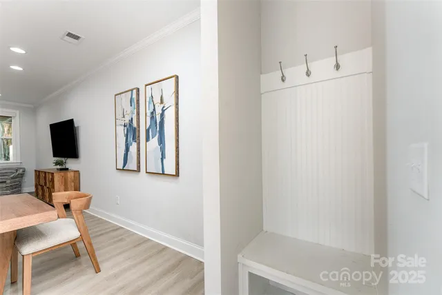 a view of a hallway with workspace and wooden floor