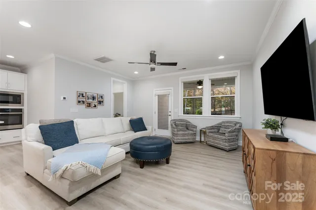 a living room with furniture flat screen tv and a large window