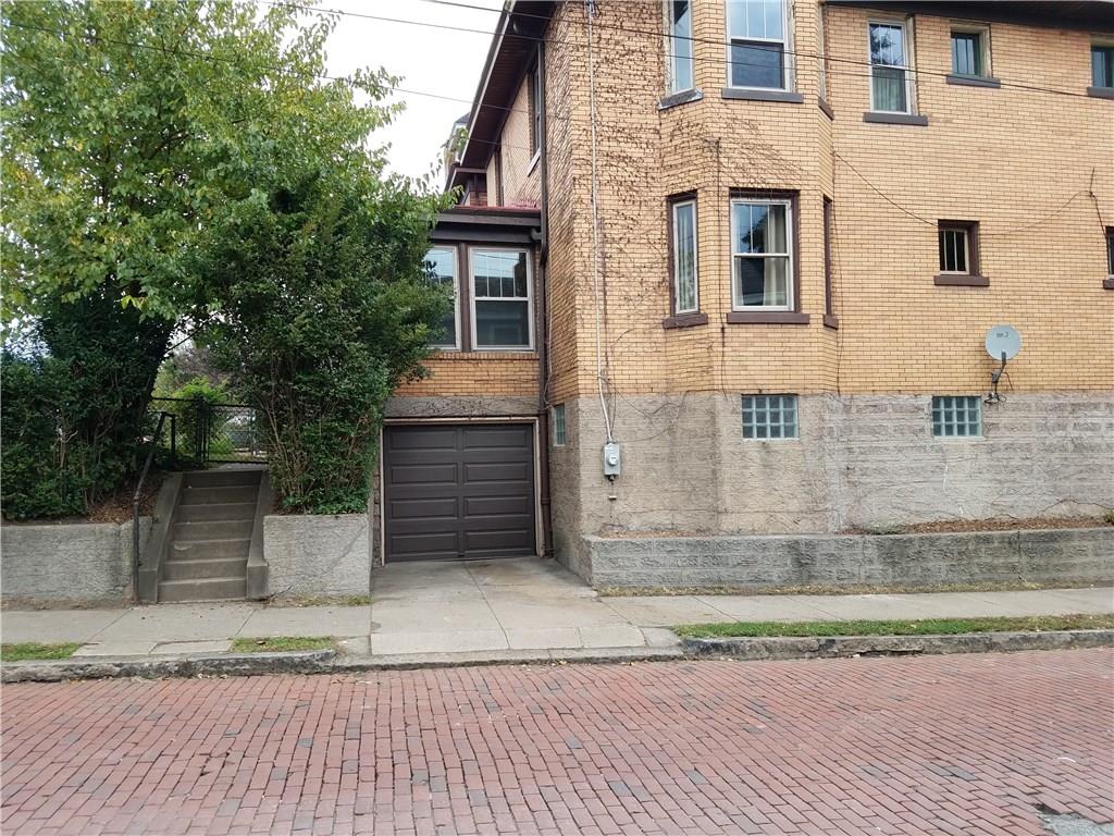 2619 Brighton Road Pittsburgh, PA 15212 - Photo 4 of 23 Steps to fenced backyard, new double pane windows, garage door and glass block basement windows. Vines on brick are being removed.