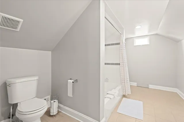 a bathroom with a granite countertop toilet and a shower