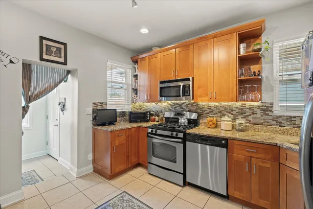 a kitchen with stainless steel appliances granite countertop a stove a sink and a refrigerator