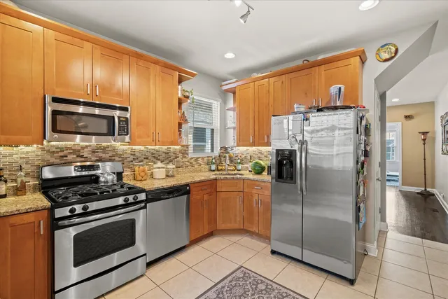 a kitchen with stainless steel appliances granite countertop a refrigerator stove and sink