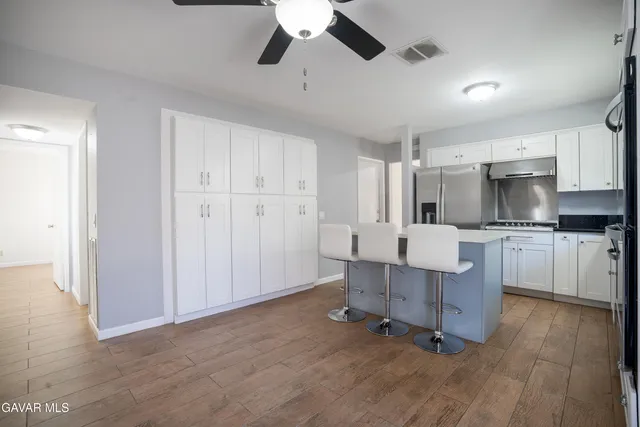 a kitchen with kitchen island white cabinets and stainless steel appliances