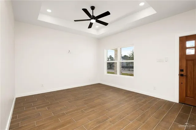 an empty room with a window and a ceiling fan