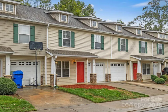 a front view of a residential apartment building with a yard and plants