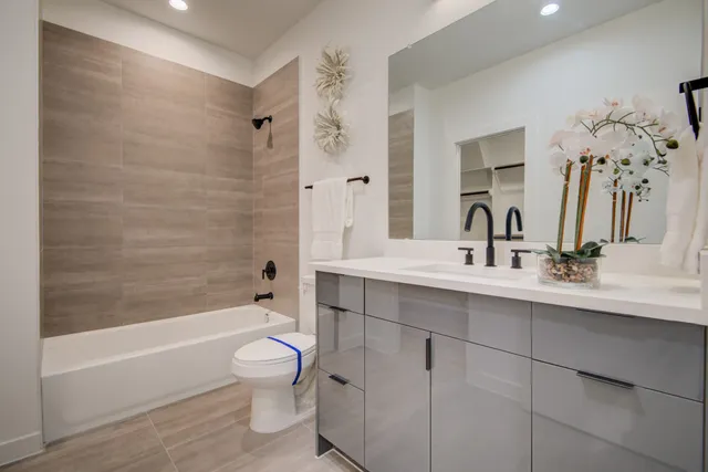 a bathroom with a toilet sink vanity tub and mirror