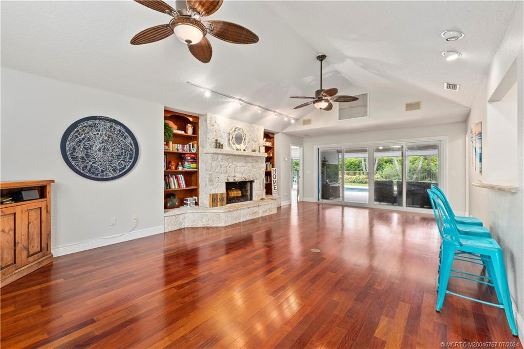 18770 Southeast River Ridge Road Jupiter, FL 33469 - Photo 13 of 81 a view of a livingroom with furniture wooden floor a ceiling fan and windows