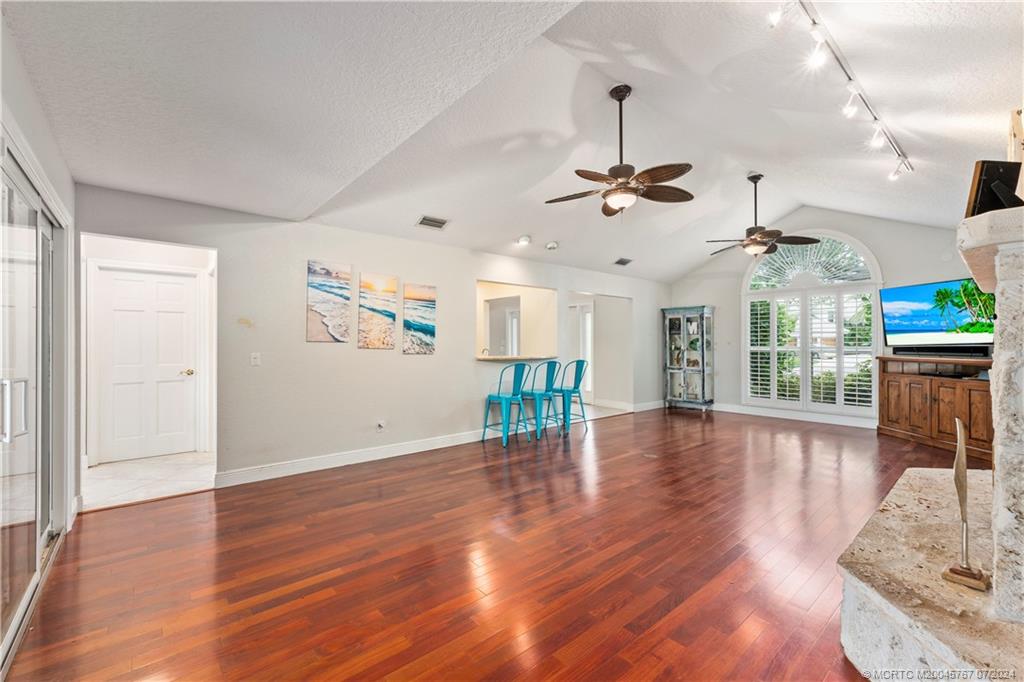 18770 Southeast River Ridge Road Jupiter, FL 33469 - Photo 17 of 81 a view of a livingroom with wooden floor a ceiling fan and windows