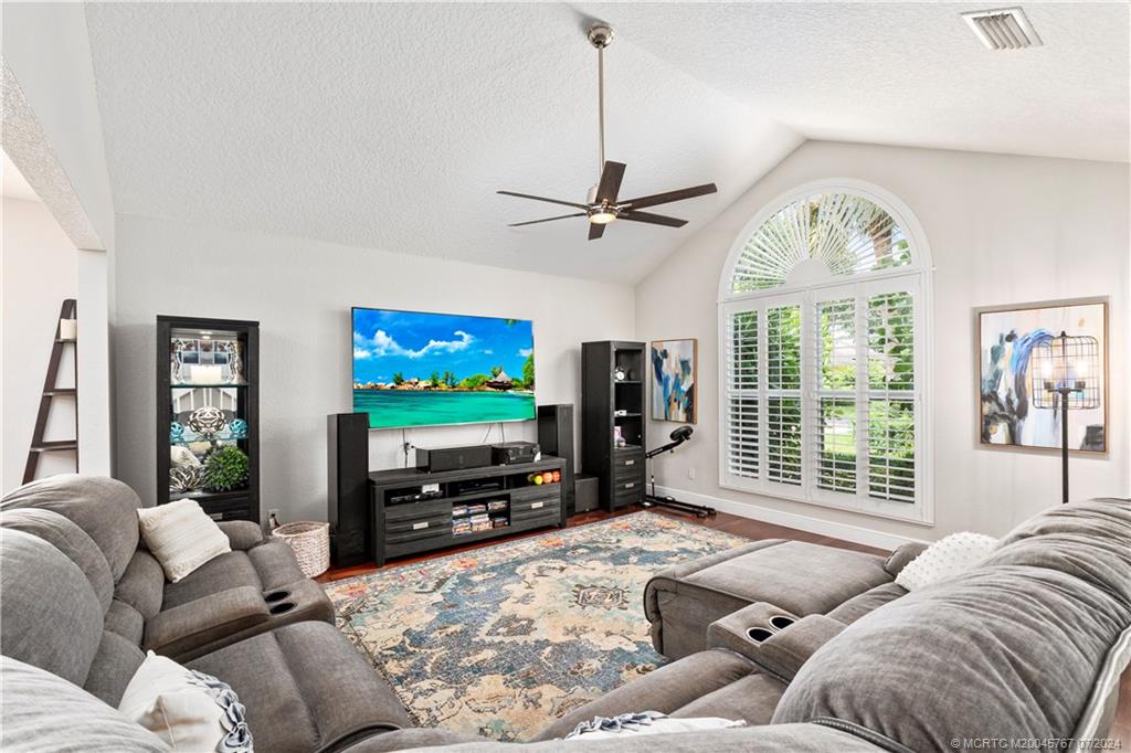 18770 Southeast River Ridge Road Jupiter, FL 33469 - Photo 20 of 81 a living room with furniture a large window and a flat screen tv