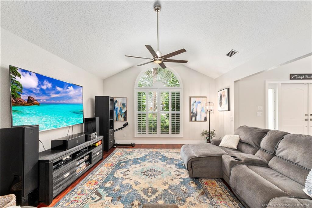 18770 Southeast River Ridge Road Jupiter, FL 33469 - Photo 21 of 81 a living room with furniture a flat screen tv and a large window
