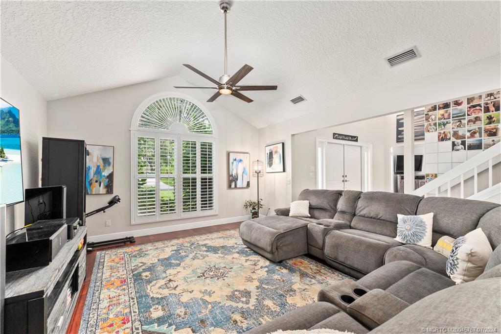 18770 Southeast River Ridge Road Jupiter, FL 33469 - Photo 22 of 81 a living room with furniture a flat screen tv and a large window