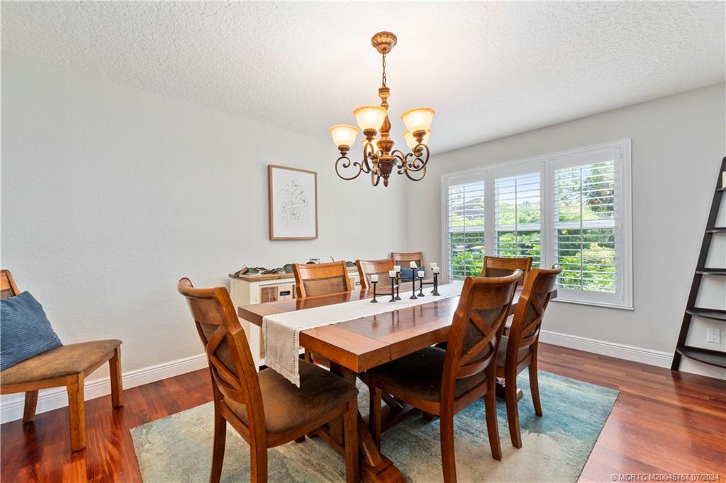 18770 Southeast River Ridge Road Jupiter, FL 33469 - Photo 26 of 81 a view of a dining room with furniture a chandelier and wooden floor