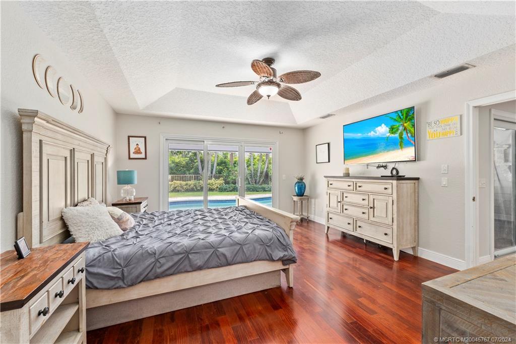 18770 Southeast River Ridge Road Jupiter, FL 33469 - Photo 29 of 81 a bedroom with a bed and a flat screen tv