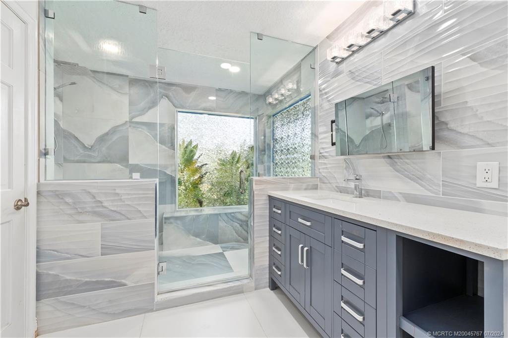 18770 Southeast River Ridge Road Jupiter, FL 33469 - Photo 32 of 81 a bathroom with a sink shower and a mirror