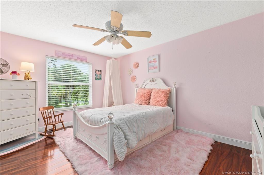 18770 Southeast River Ridge Road Jupiter, FL 33469 - Photo 45 of 81 a bedroom with a bed and a chandelier