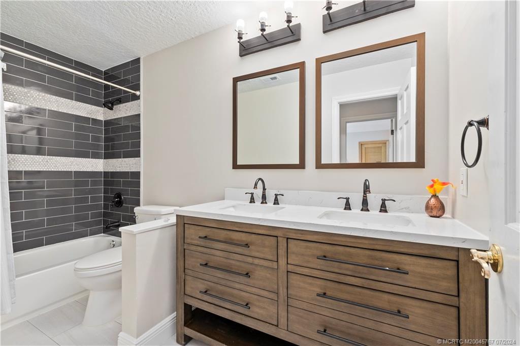 18770 Southeast River Ridge Road Jupiter, FL 33469 - Photo 46 of 81 a bathroom with a granite countertop sink vanity mirror bathtub and toilet