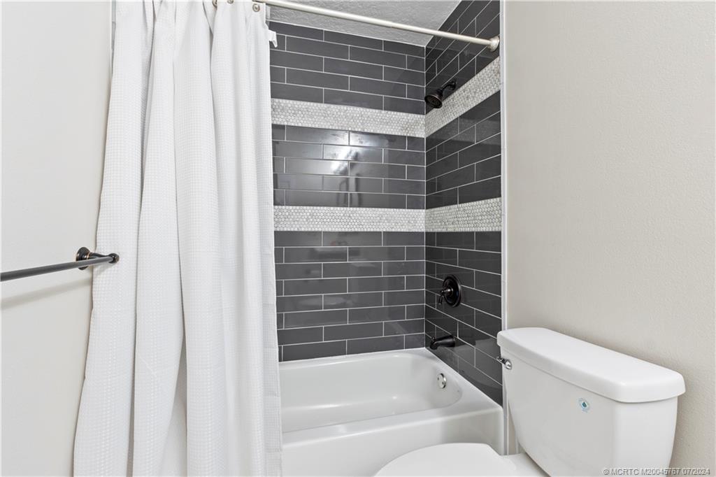 18770 Southeast River Ridge Road Jupiter, FL 33469 - Photo 47 of 81 a bathroom with a bathtub and a toilet