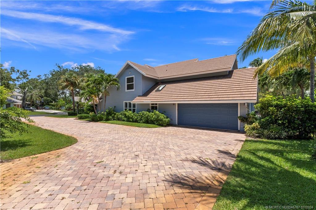 18770 Southeast River Ridge Road Jupiter, FL 33469 - Photo 70 of 81 a front view of a house with a yard and garage