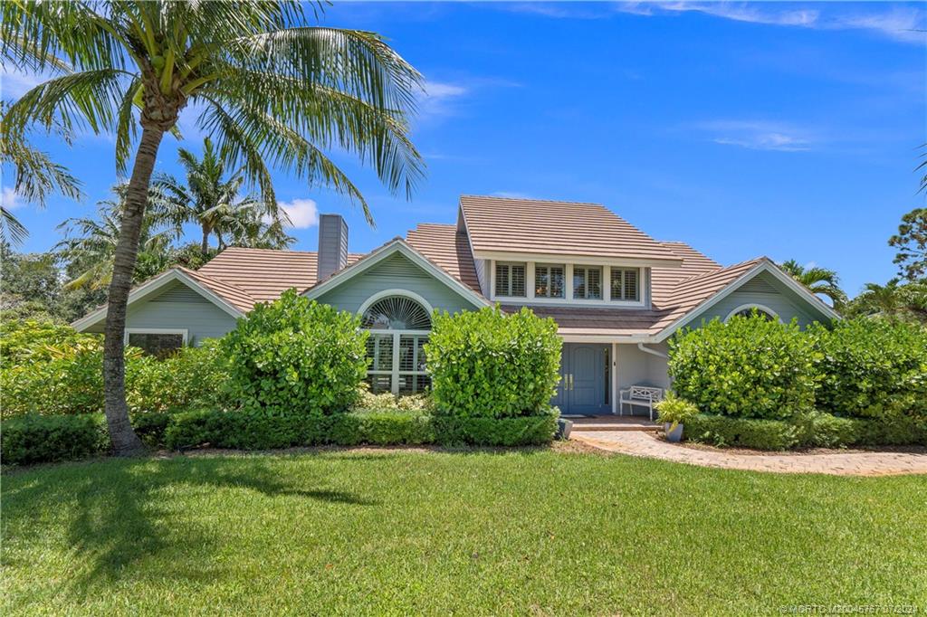 18770 Southeast River Ridge Road Jupiter, FL 33469 - Photo 80 of 81 a front view of a house with a garden