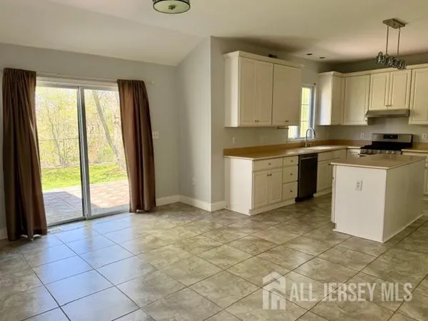 a large kitchen with kitchen island granite countertop a stove a sink and a refrigerator