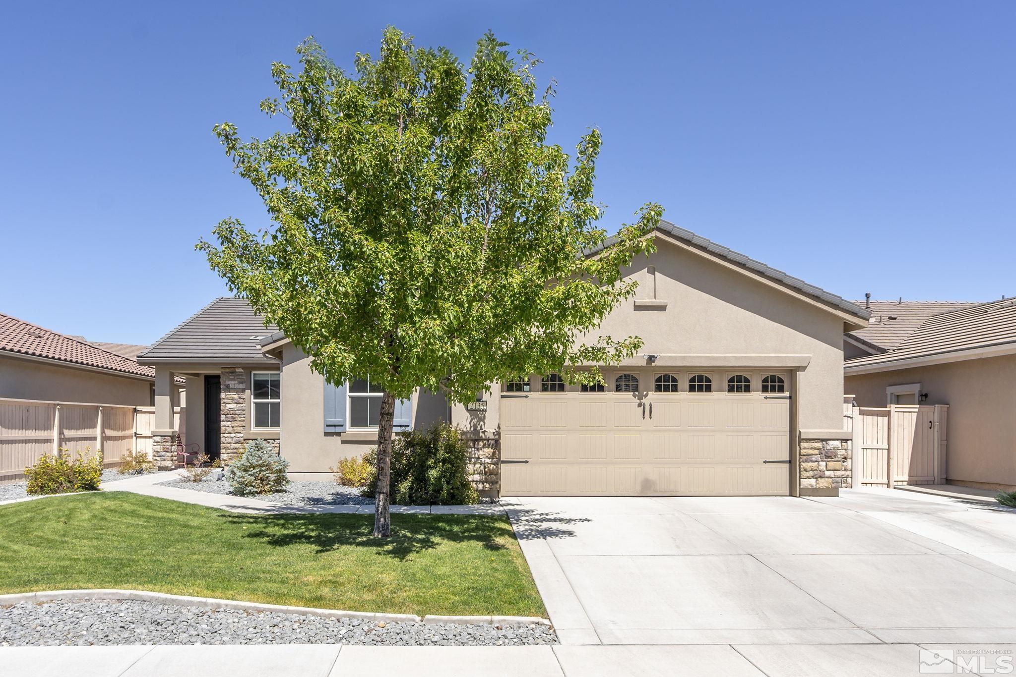 2135 Blue Oaks Drive Reno, NV 89521 - Photo 2 of 23 a view of a white house next to a yard with big trees