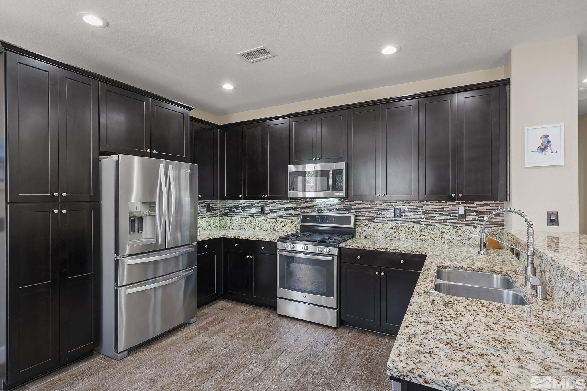 2135 Blue Oaks Drive Reno, NV 89521 - Photo 9 of 23 a kitchen with stainless steel appliances granite countertop a refrigerator a stove and a sink