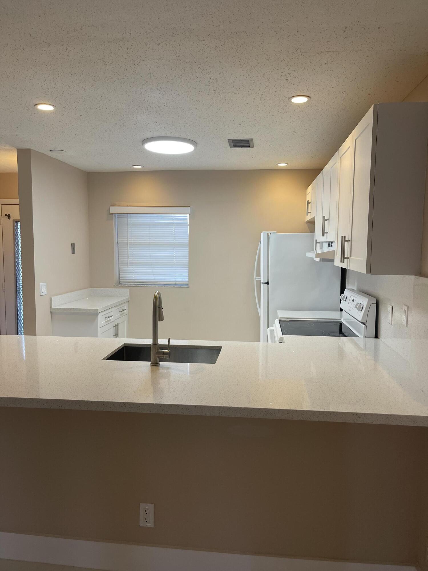 2300 Northeast 1st Lane, Unit 4020 Boynton Beach, FL 33435 - Photo 11 of 20 a kitchen with stainless steel appliances a sink a stove and a refrigerator
