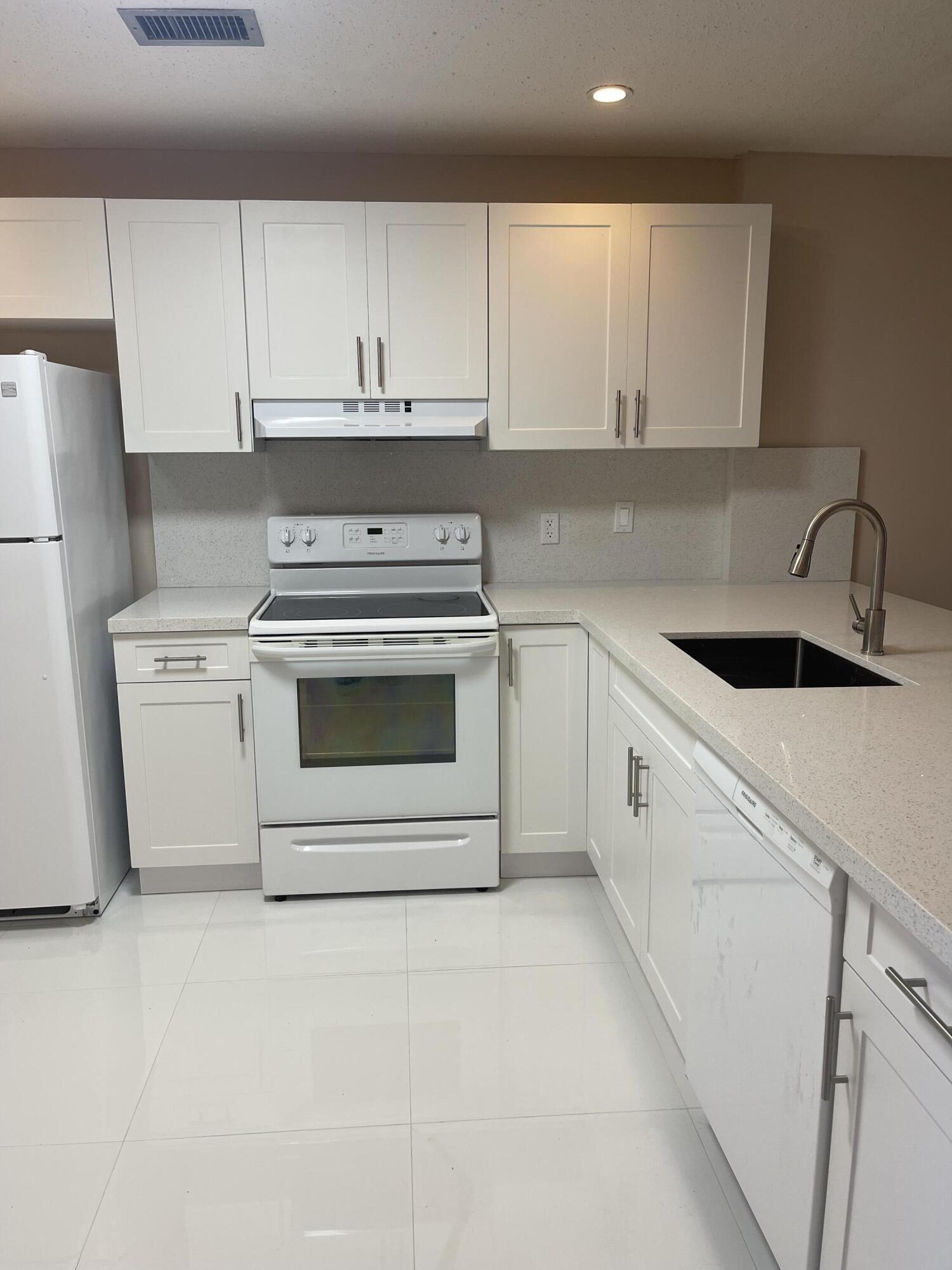 2300 Northeast 1st Lane, Unit 4020 Boynton Beach, FL 33435 - Photo 10 of 20 a kitchen with white cabinets and white appliances