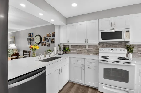 a kitchen with white cabinets and appliances