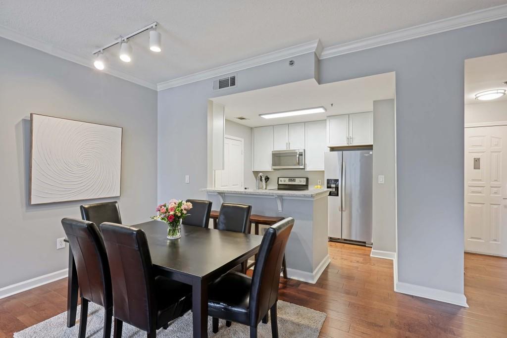 1101 Juniper Street Northeast, Unit 219 Atlanta, GA 30309 - Photo 2 of 31 a view of a dining room with furniture and wooden floor