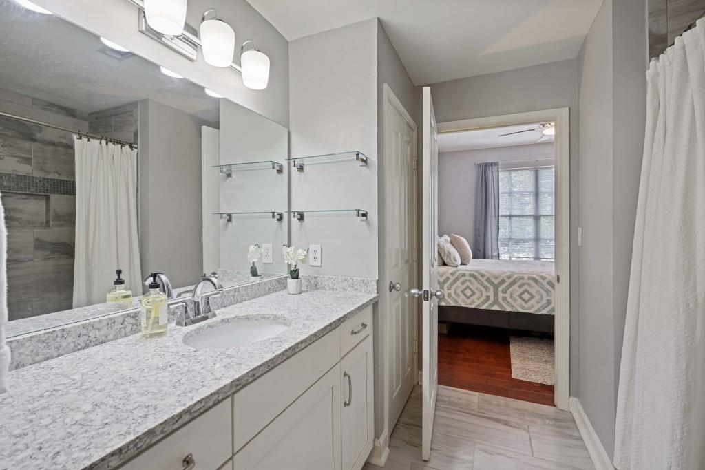 1101 Juniper Street Northeast, Unit 219 Atlanta, GA 30309 - Photo 21 of 31 a en suite bathroom with a granite countertop double vanity