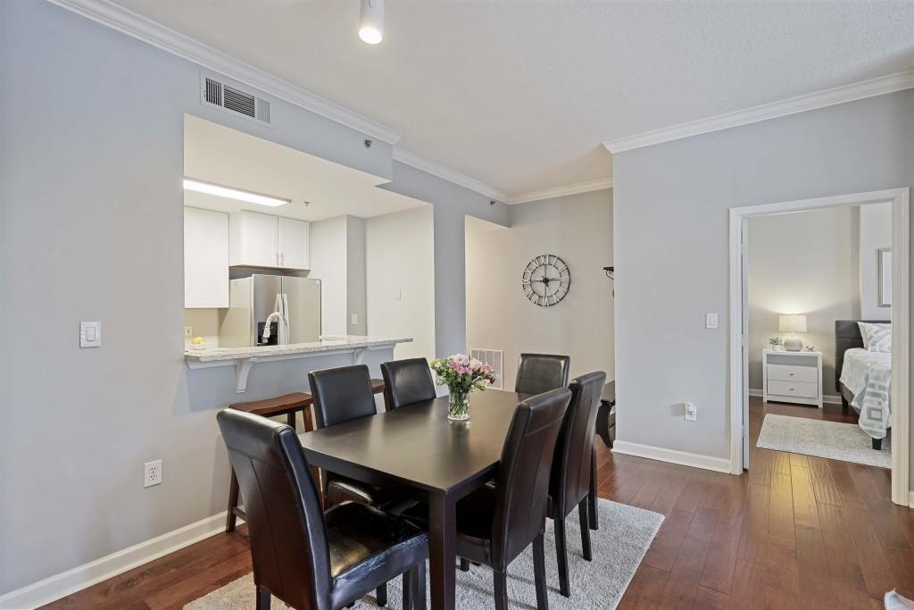 1101 Juniper Street Northeast, Unit 219 Atlanta, GA 30309 - Photo 9 of 31 a view of a dining room with furniture and wooden floor