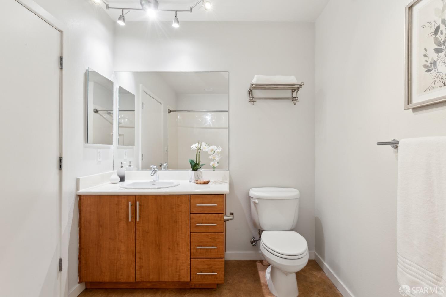 288 3rd Street, Unit 201 Oakland, CA 94607 - Photo 21 of 51 a bathroom with a toilet a sink and mirror