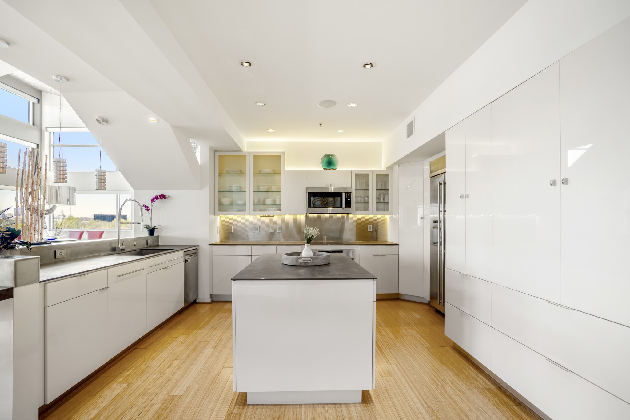 102 Quitman Street, Unit 405 Houston, TX 77009 - Photo 8 of 46 a kitchen with stainless steel appliances a stove a sink dishwasher a refrigerator white cabinets and wooden floor next to a window
