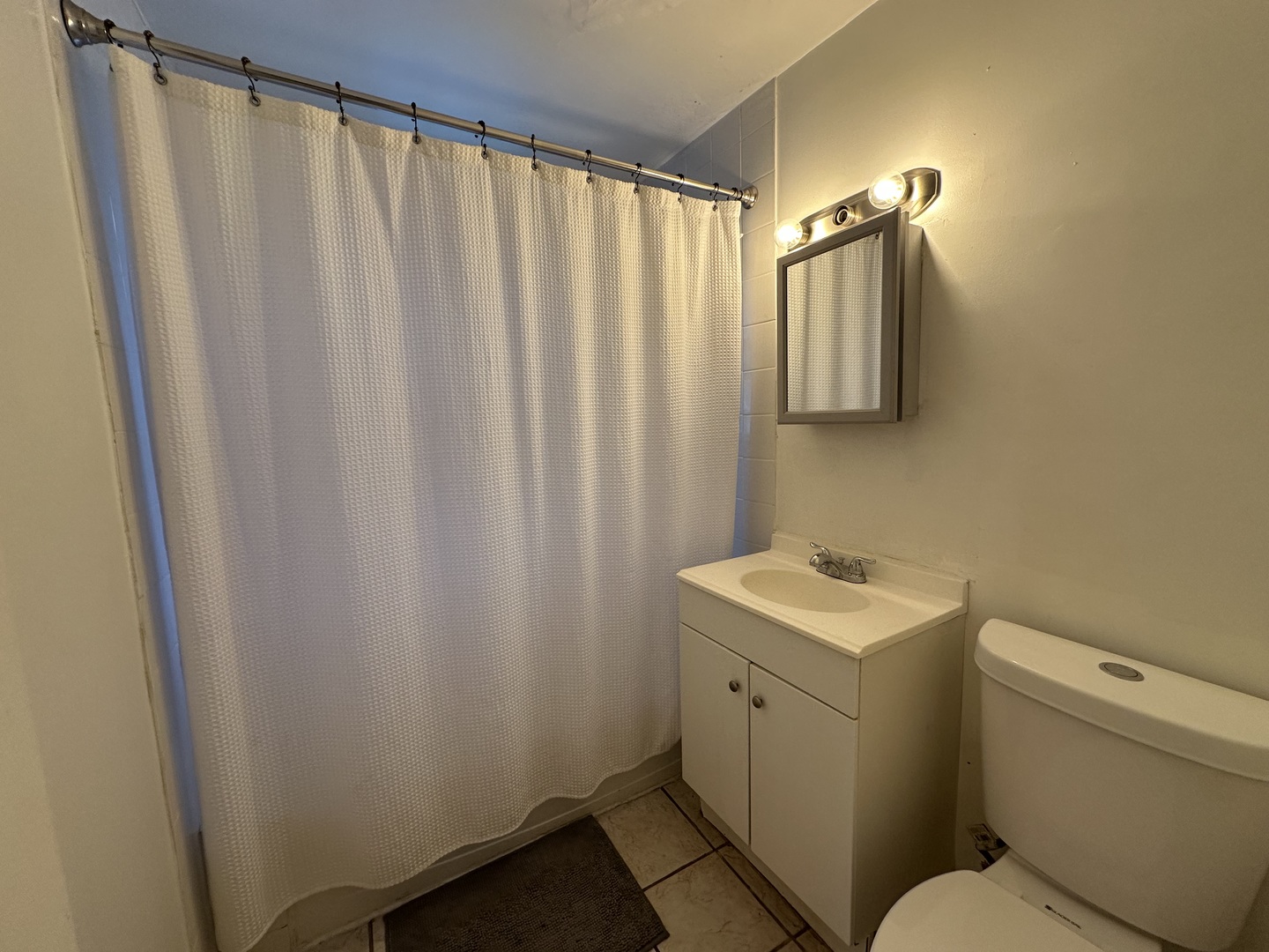 7710 South Ada Street, Unit 2 Chicago, IL 60620 - Photo 8 of 10 a bathroom with a sink a toilet and shower