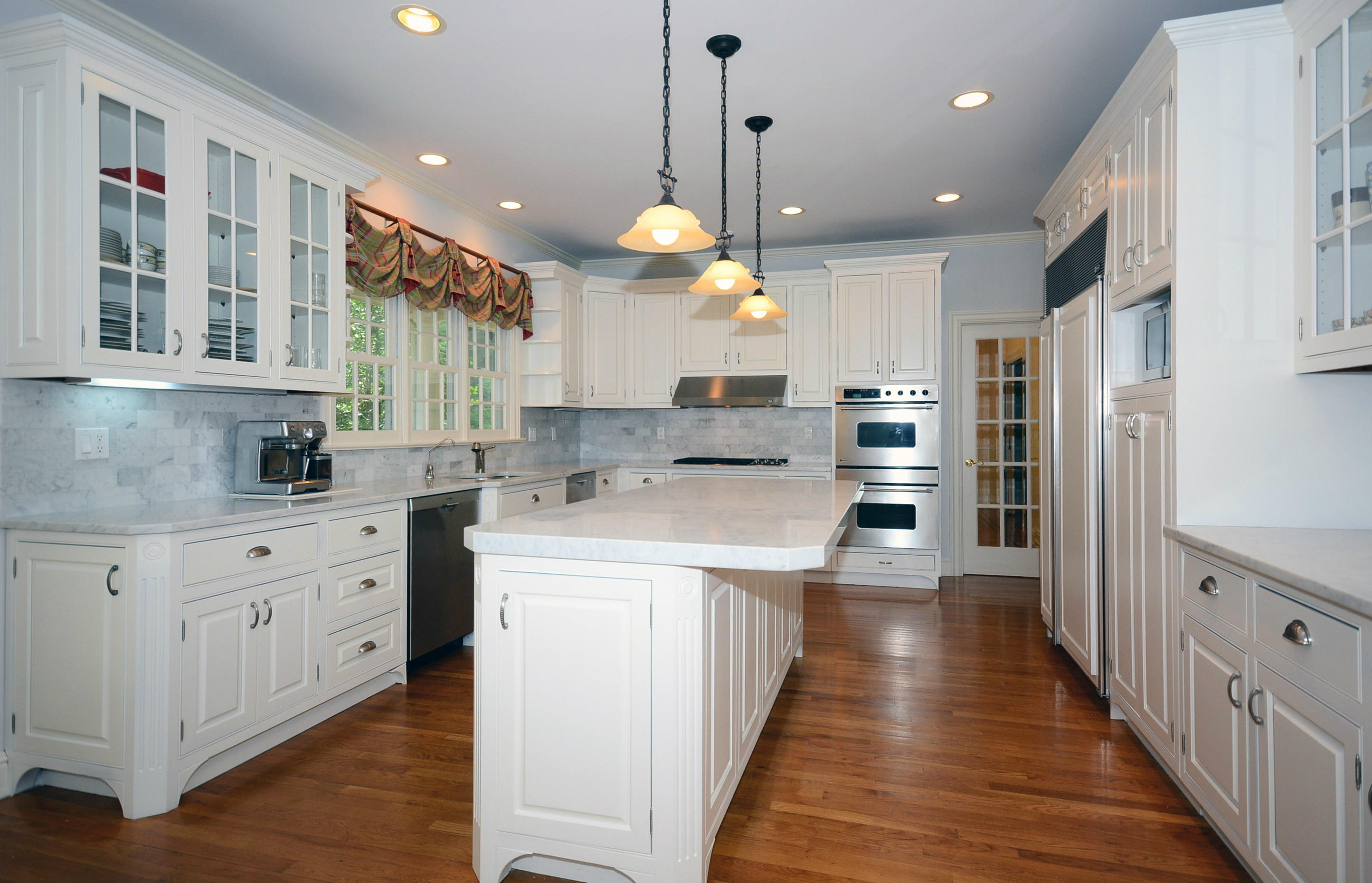 658 Valley Road New Canaan, CT 06840 - Photo 12 of 23 a large kitchen with stainless steel appliances kitchen island granite countertop a large kitchen island a stove a refrigerator a sink dishwasher and white cabinets with wooden floor