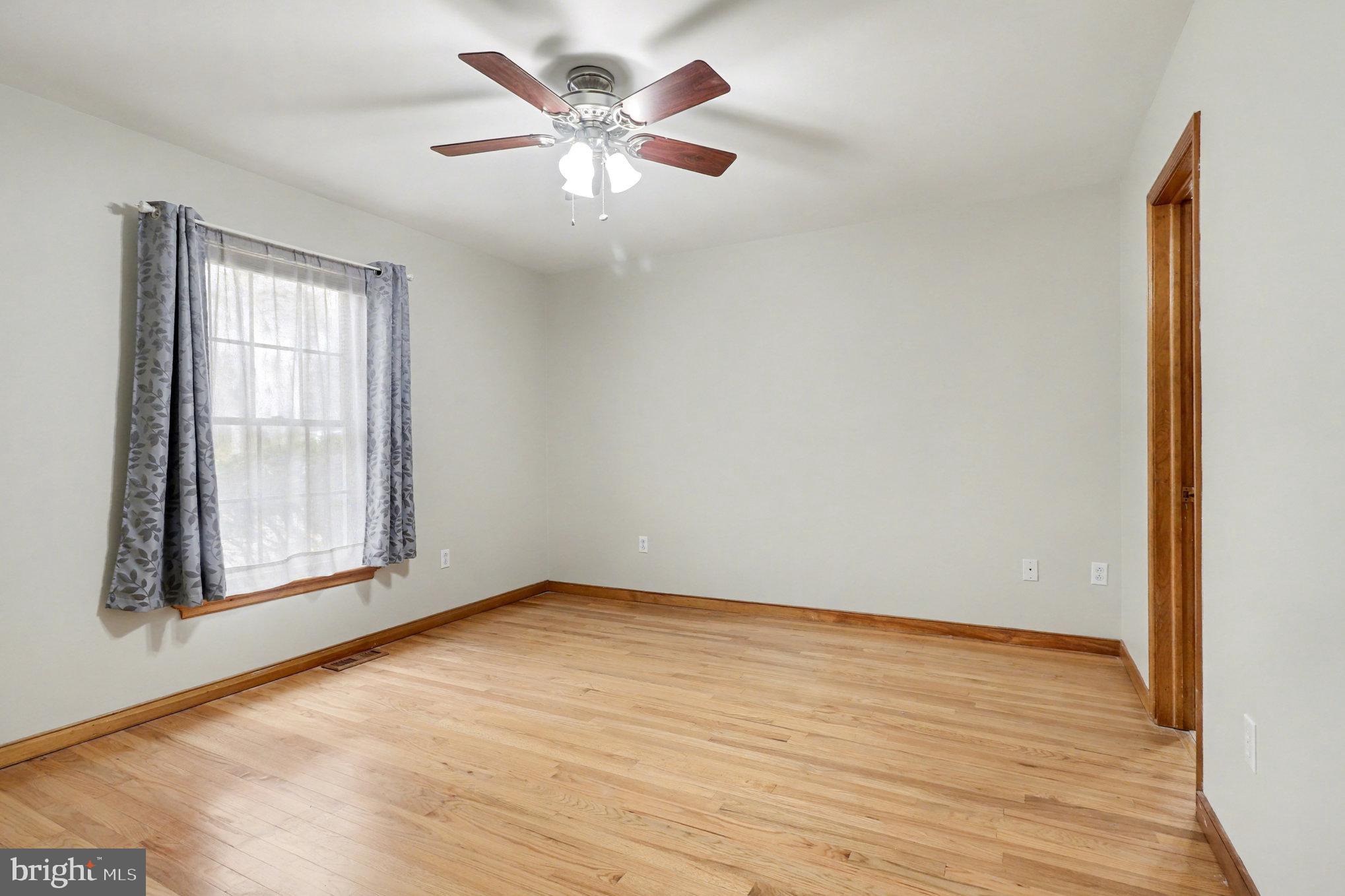 259 Hawkins Farm Road Bumpass, VA 23024 - Photo 12 of 24 an empty room with wooden floor and windows