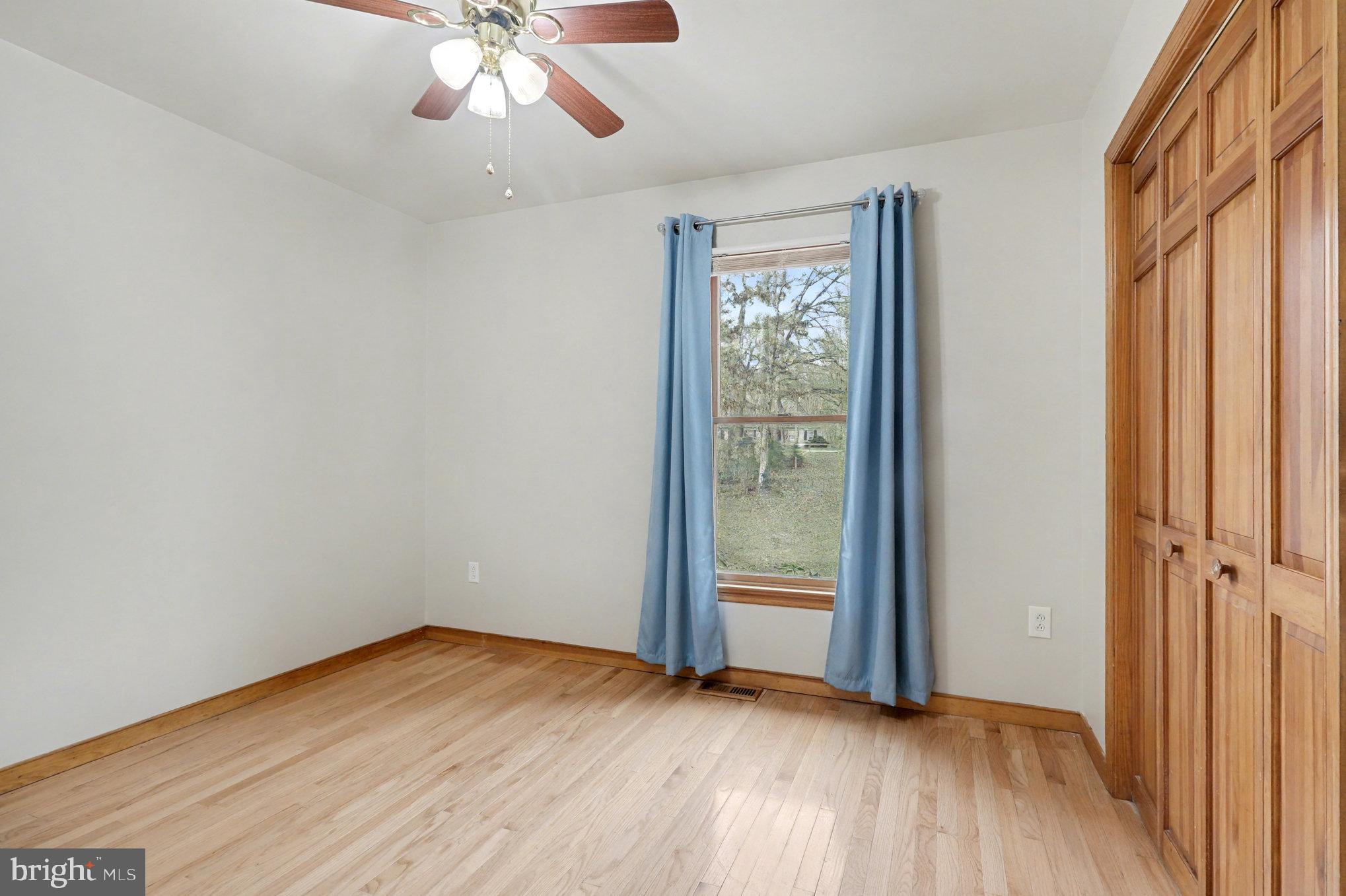 259 Hawkins Farm Road Bumpass, VA 23024 - Photo 16 of 24 an empty room with wooden floor fan and windows